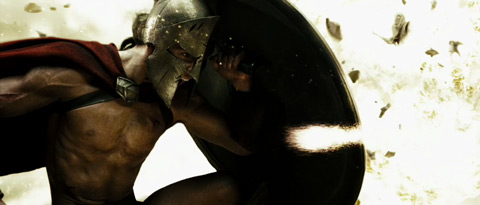 A Spartan crouches behind his shield to repel the blast of a hand-thrown explosive.
