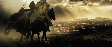 Horsemen ride along a hill towards Sparta, which sits beneath shafts of sunlight.