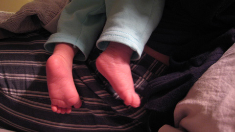Blackbird's little feet sticking out of her light blue pants, her legs hanging down from Alisa's lap.
