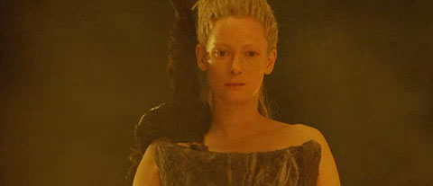 The white witch leads a dark ceremony with a raven's wing on her shoulder.