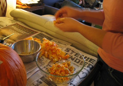 Rebecca separates out the pumpkin seeds from the mush. 