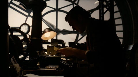 The silhouetted narrator, Lemony Snicket, leans over his typewriter.