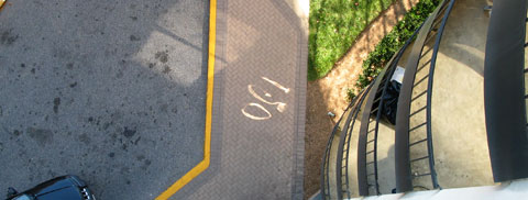 Distorted numerals reflected on a sidewalk far below.