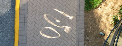 Distorted numerals reflected on a sidewalk.