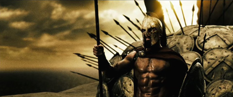Leonidas, with his helmet and spear, stands in front of his remaining soldiers, who've formed a dome of sheilds bristling with spears.
