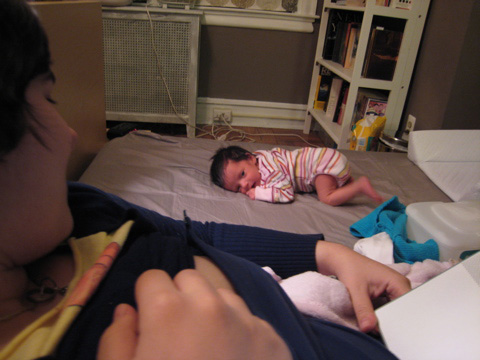 Blackbird laying on our bed while Alisa looks on from the other side.