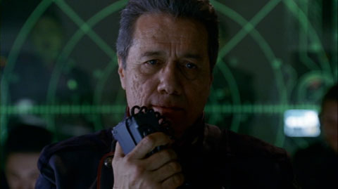 Cmdr. Adama using his comm set on the bridge.