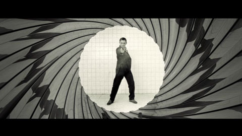 James Bond, played by Daniel Craig, pointing his gun at the camera, as seen down the barrel of another gun.