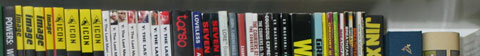 A row of graphic novels' spines, cropped to show only the top.