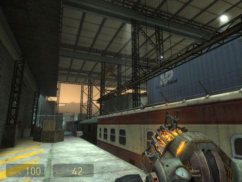 Looking out towards the opening of the train hangar where cargo cars and passenger cars are stationed.