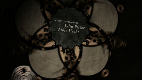 A stylized pinwheel spins around with the credits over top of the center axis