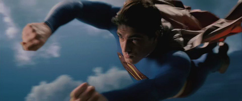 A closeup of Superman flying fast through a cloudy sky.
