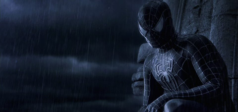 Spider-Man, in his black suit, looks a the viewer through the rain.