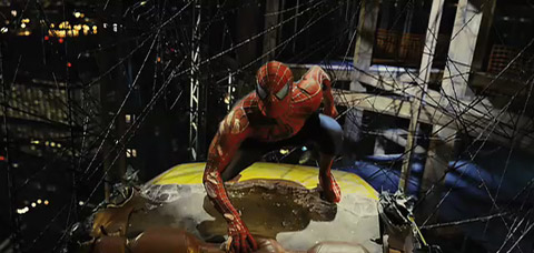 Spider-Man, in his regular blue and red suit, crouches on a yellow cab, caught in a black web above the city.