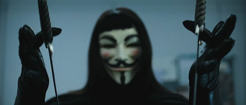 V, close up and without his hat, spinning his knives around his fingers.